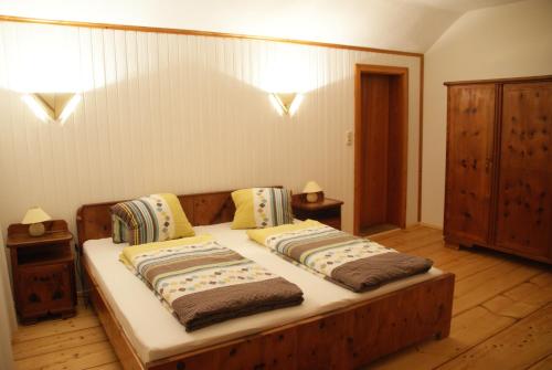 a bedroom with a wooden bed with two pillows at Ferienwohnung Bluntaumühle in Golling an der Salzach