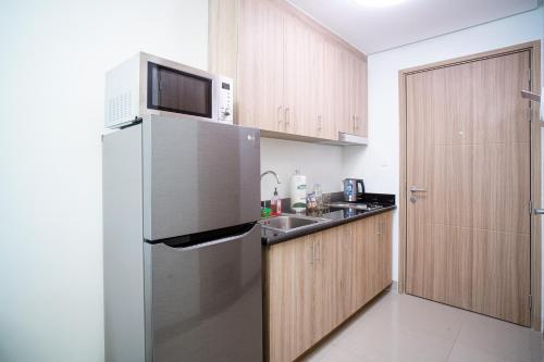 a kitchen with a stainless steel refrigerator and a sink at Tatet Suites Staycation Short Walk to SM MOA in Manila