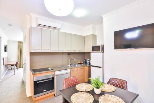 a kitchen with a table and chairs in a room at Indulge Apartments - Ontario in Mildura