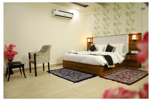 a bedroom with a bed and a desk and a chair at Hotel Signature Prime Vaishali Nagar Jaipur in Jaipur