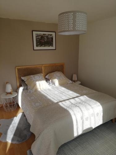 - une chambre avec un grand lit et une couverture blanche dans l'établissement Kerlan 5, à Béganne