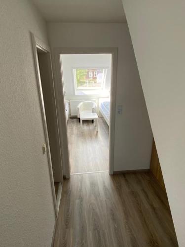 a hallway with a room with a bed and a window at Hotel Braunlage in Braunlage