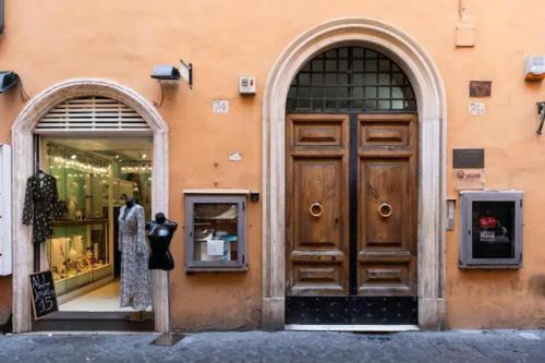 a store front with a large wooden door and two windows at Croce Apartments in Rome