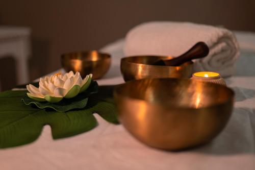 a group of gold candles and a flower on a table at Casa Vacanze Fiore di Loto in Leporano