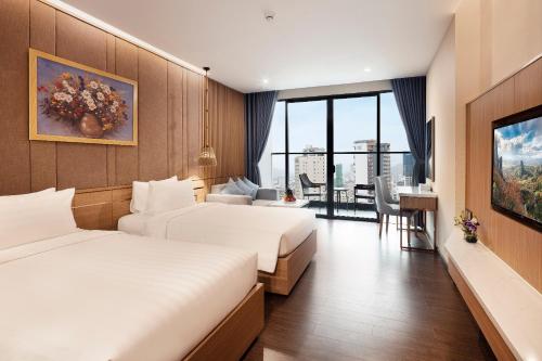 ニャチャンにあるVirgo Hotel Nha Trangのベッド2台、テーブルと椅子が備わるホテルルームです。