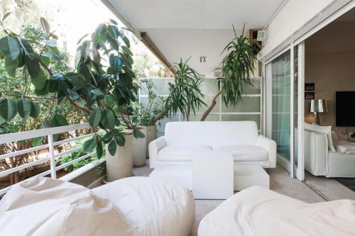 un soggiorno con mobili bianchi e piante di Lux Beach Apartment a Vari