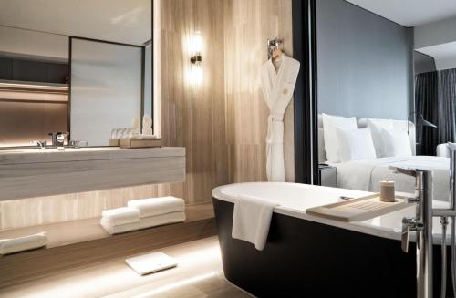 baño con bañera, cama y lavamanos en Pullman Shenzhen North en Shenzhen