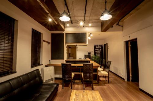 a living room with a table and chairs and a kitchen at LifeHouse IPPO in Otaru