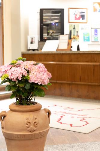 a vase filled with pink flowers in a store at Country Hotel Residence Da Pilade in Capoliveri