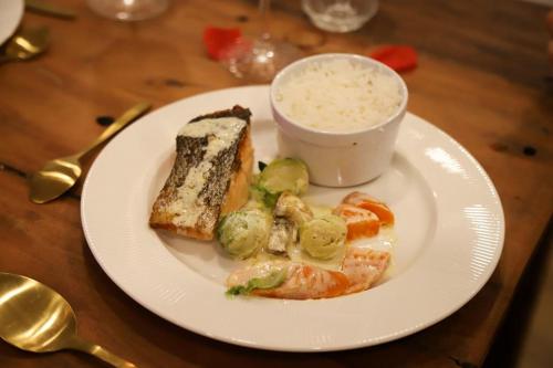 Un plato blanco con un sándwich y un tazón de arroz. en Love room Unique - Sauna / Jacuzzi en Charleville-Mézières