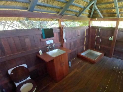 ein Badezimmer mit einem WC, einem Waschbecken und einer Badewanne in der Unterkunft Village Fig River Camp in Chiawa