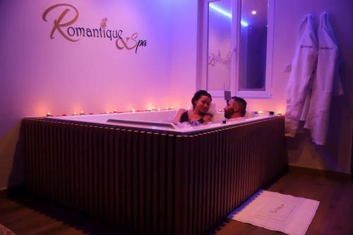 a man and woman in a bathtub in a room at Love room Unique - Sauna / Jacuzzi in Charleville-Mézières