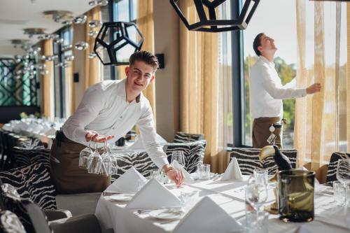 two men standing in a dining room with tables at Van der Valk Hotel Heerlen in Heerlen