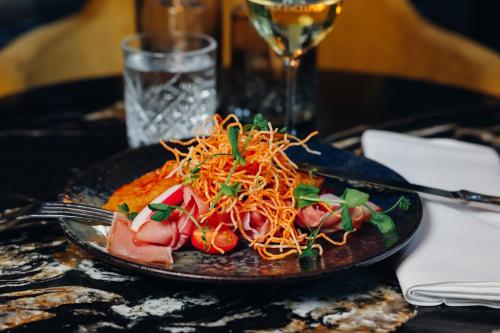 a plate of food with spaghetti and tomatoes on a table at Van der Valk Hotel Heerlen in Heerlen
