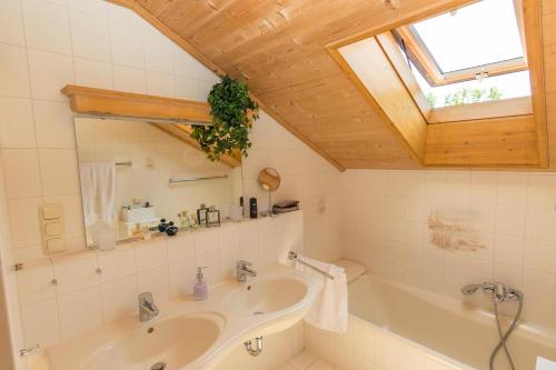baño con lavabo, bañera y ventana en Alpenliebe en Alterschrofen