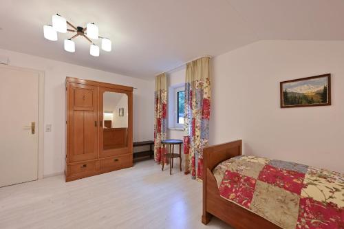 um quarto com uma cama, uma mesa e uma porta em Ferienwohnung Landhaus Helga unterm Schloss em Schwangau