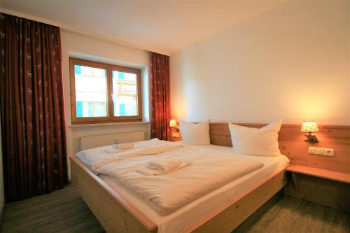 a bedroom with a large white bed with a window at Ferienwohnung Vera in Schwangau