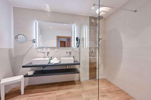 a bathroom with a shower and a sink and a mirror at Monusse Boid Wohnung 6 in Pfronten