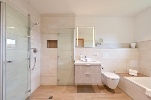 a bathroom with a shower and a sink and a toilet at Landhaus am See Appartement LH 1 in Schwangau