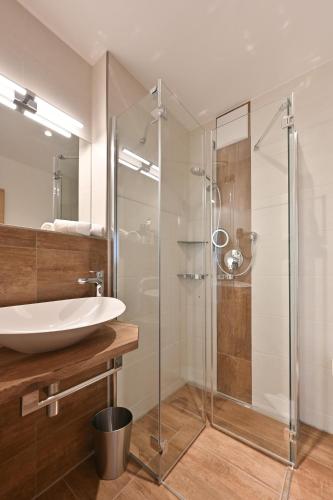 a bathroom with a sink and a glass shower at Monusse Boid Wohnung 1 in Pfronten