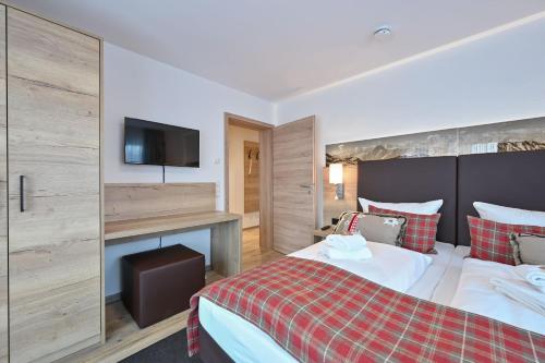 ein Hotelzimmer mit einem Bett und einem Flachbild-TV in der Unterkunft Monusse Boid Wohnung 11 in Pfronten