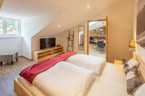 a bedroom with a large bed and a television at Monusse Boid Wohnung 12 in Pfronten