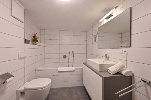 a white bathroom with a toilet and a sink at Ferienwohnung Sophia in Pfronten