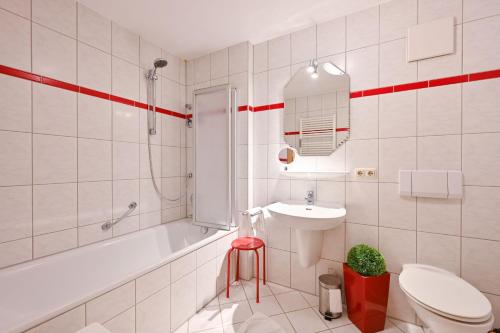 a bathroom with a sink and a toilet and a tub at Ferienwohnung Am Kienberg in Pfronten