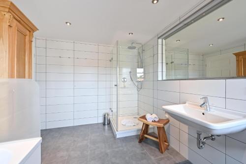 a white bathroom with a sink and a mirror at Ferienwohnung Rommel in Pfronten