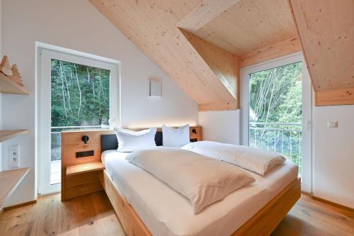 a bedroom with a large bed and large windows at Ferienwohnung Zugspitze in Pfronten