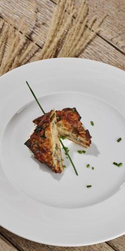 a white plate with a piece of food on it at Borgo della Spiga - Adult Friendly Country House in Cervidone