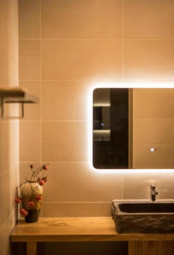 a bathroom with a sink and a mirror on the wall at Dali Dream House with Seaview in Dali