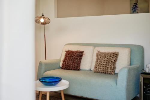 a blue couch with pillows and a table in a room at Borgo della Spiga - Adult Friendly Country House in Cervidone