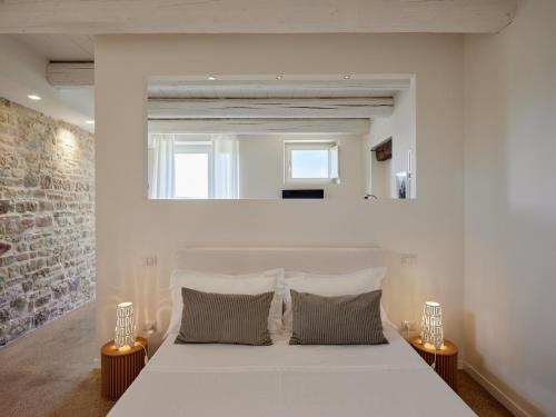 a bedroom with a large white bed with two lamps at Borgo della Spiga - Adult Friendly Country House in Cervidone