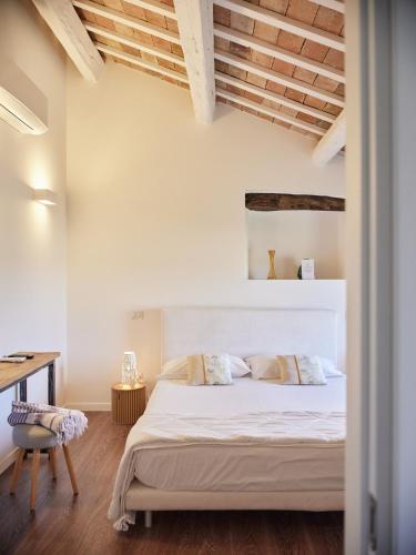 a bedroom with a white bed and a desk at Borgo della Spiga - Adult Friendly Country House in Cervidone
