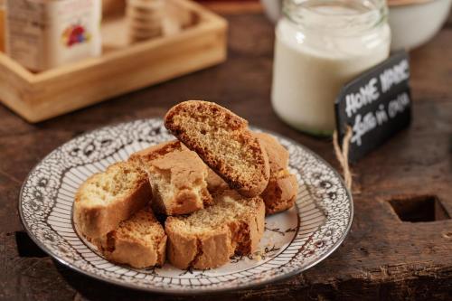 a plate with slices of bread on a table with milk at Borgo della Spiga - Adult Friendly Country House in Cervidone