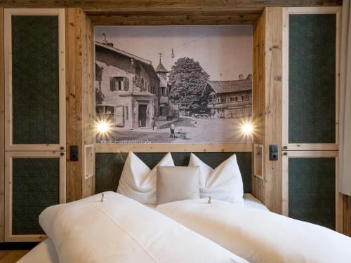two beds in a room with a picture on the wall at Kirchenwirt Wörgl in Wörgl