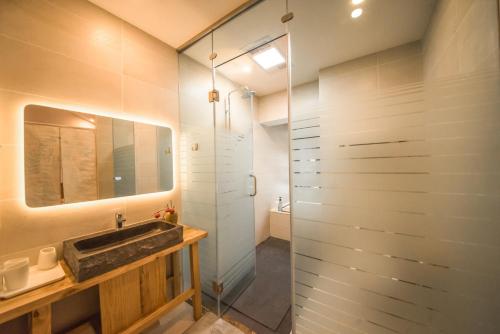 a bathroom with a sink and a glass shower at Dali Dream House with Seaview in Dali