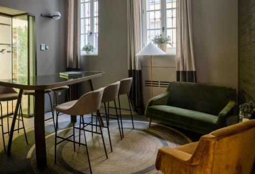 uma sala de estar com um sofá verde e uma mesa e cadeiras em Bellacorte Gentiluogo per Viaggiatori em Parma