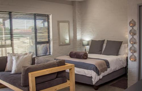 a bedroom with a large bed and a couch at Dragon Tree in Yzerfontein