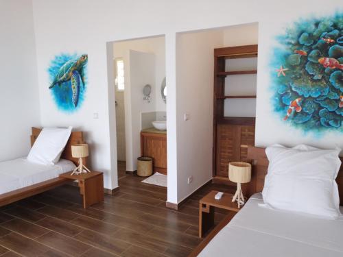 Cette chambre comprend deux lits et un tableau mural. dans l'établissement Belamandy Lodge, à Anjramarango