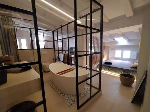 a bathroom with a bath tub and a bedroom at Charming loft in the heart of El Carmen Valencia in Valencia