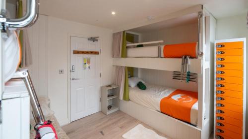 a small room with a bed and bunk beds at Lakes Boutique Hostel Apartment Windermere in Windermere