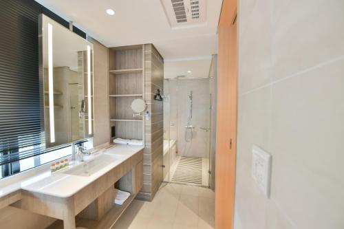 a bathroom with a sink and a shower at CHECK inn Select New Taipei Sanchong in Taipei