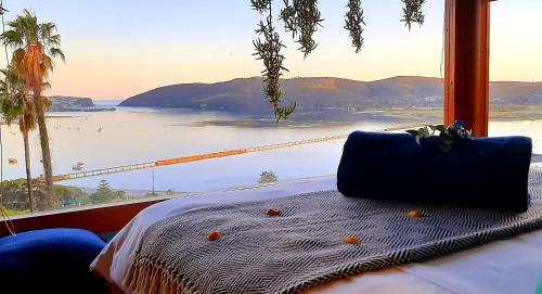 uma cama num quarto com vista para uma ponte em Paradise Private Zen Studios em Knysna