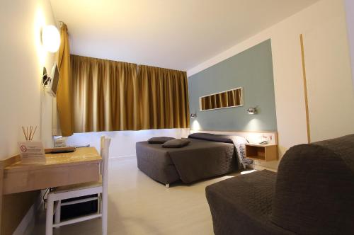 a hotel room with two beds and a desk and a bed sidx sidx sidx sidx at Hotel Giardino in Breno