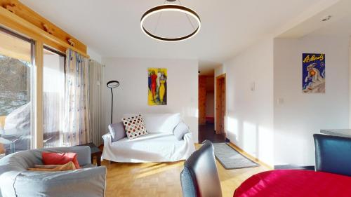 a living room with white furniture and a large window at Rosatsch 14 in Surlej