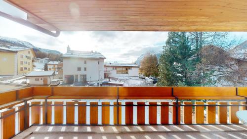 a balcony with a view of a snowy city at Rosatsch 14 in Surlej