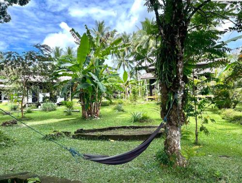 a hammock tied to a tree in a yard at Sanctum Una Una Eco Dive Resort in Pulau Unauna