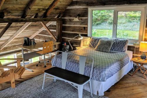 Dormitorio con cama y escritorio en una cabaña en A charming, rustic 150 year old Carriage House, en Orangeville